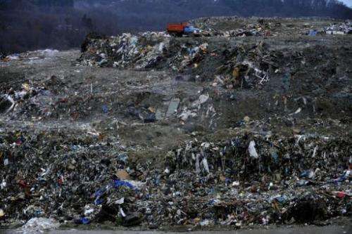 Trucks unload rubbish at a dumping ground near the village of Gorny Vozdukh near Sochi on February 21, 2013
