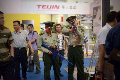 Two Chinese paramilitary police test a telescopic sightat a police technology fair in Beijing on May 15, 2013