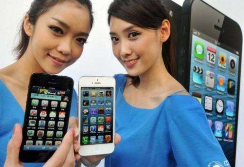 Two women display the Apple iPhone 5 during the product's release at a store in Taipei on December 14, 2012