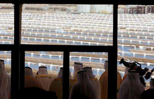 UAE officials look from a balcony at the Shams 1, concentrated solar power plant, in al-Gharibiyah district on the outskirts of 