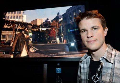 Ubisoft developer Dominic Guay stands beside a screenshot of &quot;Watch Dogs&quot; at the E3 conference in LA on June 12, 2013