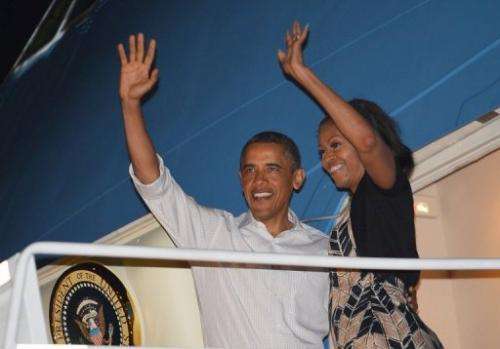 US President Barack Obama and First Lady Michelle Obama (R) wave as they board Air Force One on January 5, 2013