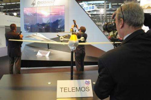 Visitors take pictures on French Dassault Aviation stand of models of &quot;Telemos,&quot; a MALE drone project, at Eurosatory 2