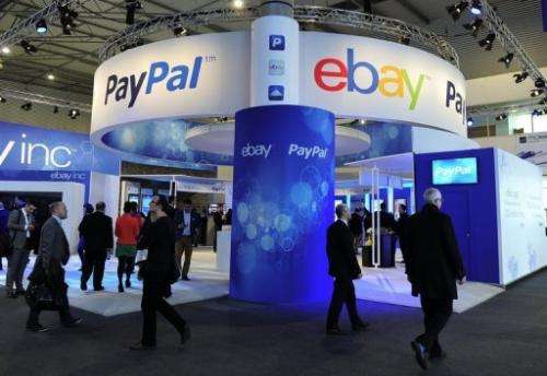 Visitors walk past an Ebay and PayPal stand at the Mobile World Congress in Barcelona on February 27, 2013