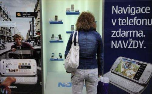 Woman looks at mobile phones on display on May 7, 2010 in Prague