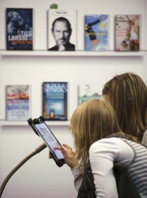 Women try out Deutsche Telekom's PagePlace eBook reader app at the Leipzig Book Fair on March 15, 2012
