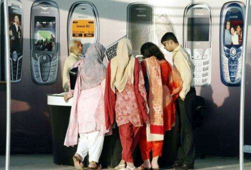 Women visit a stall a mobile phone exhibition in Islamabad on June 19, 2005