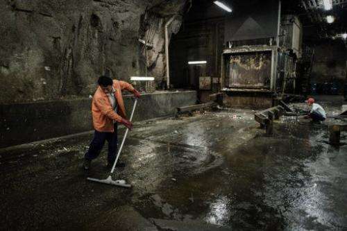 Workers at an underground cavern where waste is prepared prior to being transferred to landfills, on March 6, 2012