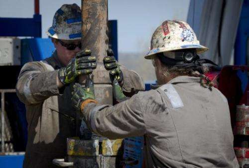 Workers change pipes at a rig exploring the Marcellus Shale outside the town of Waynesburg in Pennsylvania