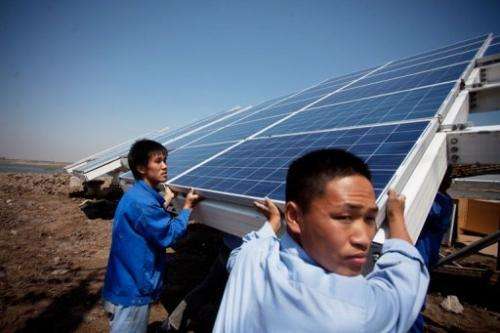 Workers install solar panels at the Sino-Singapore Eco-city near Tianjin on June 11, 2012