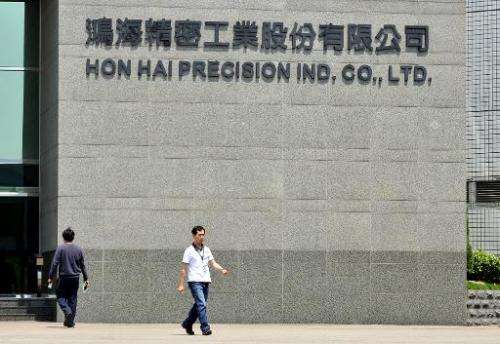 Workers walk in front of Hon Hai's headquarters in Tuchung city, northern Taiwan on June 7, 2010