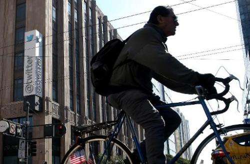 A cyclist rides past the Twitter headquarters in San Francisco on October 25, 2013