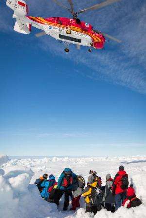 A helicopter from the Chinese icebreaker Xue Long hovers above passengers from the stranded Russian ship Akademik Shokalskiy in 