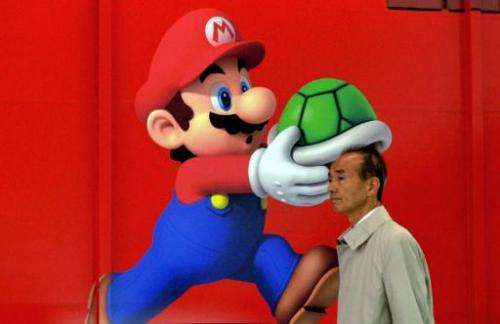 A man walks past a poster of Nintendo video game character Super Mario at an electronics shop in Tokyo on April 24, 2013