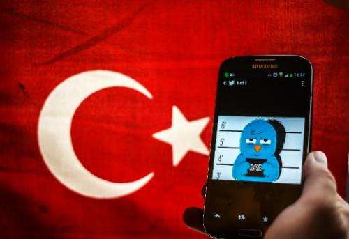 A picture representing a mugshot of the twitter bird is seen on a smart phone with a Turkish flag in Istanbul on March 26, 2014