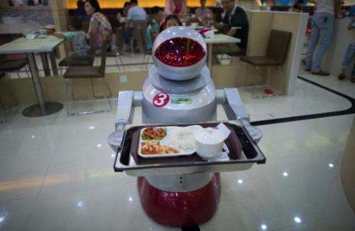A robot carries food to customers in a restaurant in Kunshan on August 13, 2014