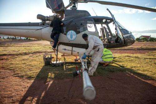 A team prepares a helicopter equipped with pesticide-spreading equipment to fight a locust plague in Tsiroanomandidy, Madagascar