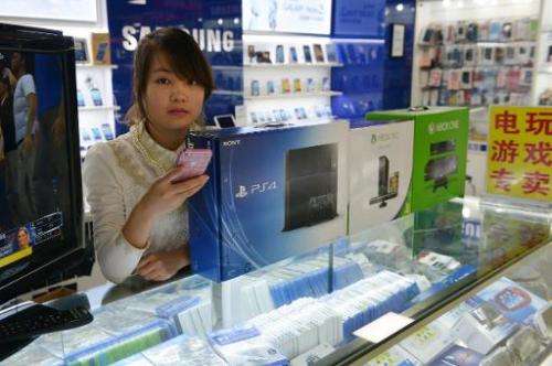 A vendor sells game consoles including Xbox One and Sony's PS4 in a major electronics market in Shanghai on January 8, 2014