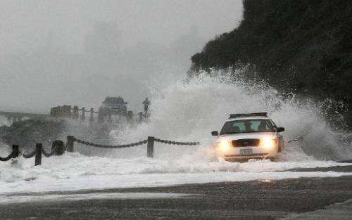 A wave crashes over a US Park Police patrol car on January 20, 2010, at Fort Point in San Francisco, California