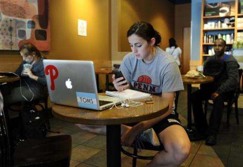 A woman uses her smartphone in a starbucks in Silver Spring, Maryland, on May 9, 2012
