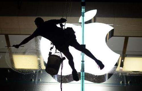 A worker cleans glass panels of the Apple store in the central business district in Sydney, April 8, 2013