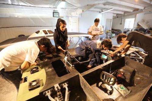 Iranian students from the Qazvin Azad Islamic University assemble the solar-powered Havin-2 vehicle for a test drive in Qazvin o