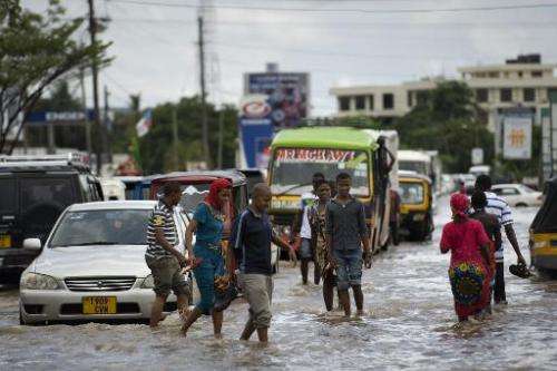 Pedestrians cross the flooded Old Bagamoyo Road in the Mikocheni area of Dar es Salaam, Tanzania, on April 12, 2014