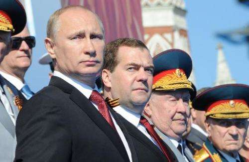 Russia's President Vladimir Putin (L) and Prime Minister Dmitry Medvedev (2nd L) attend a Victory Day parade at the Red Square i