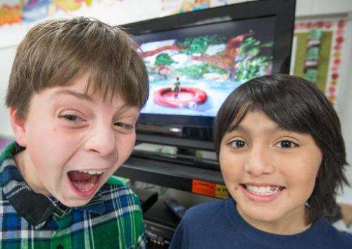 Sawyer Whitely (L), 10, and Michael Mendoza, (also 10), who are autistic, pose for a photo while playing selected games on a Mic
