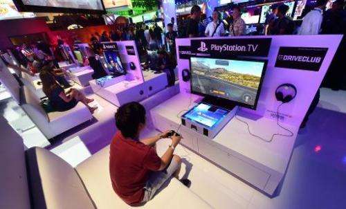 A file picture taken in Los Angeles, California on June 10, 2014 shows people testing the new Playstation consoles at the annual