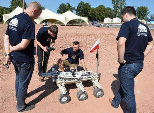 Members of the Kielce University of Technology team watch their &quot;Impuls&quot; Mars rover before the European Rover Challeng