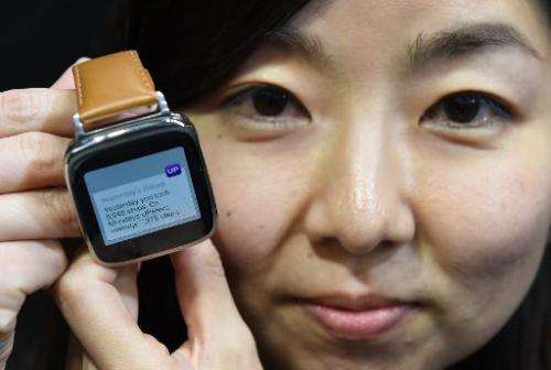 An employee of Taiwan's ASUS TeK Computer shows its new smartwatch during a press conference in Tokyo, on October 28, 2014