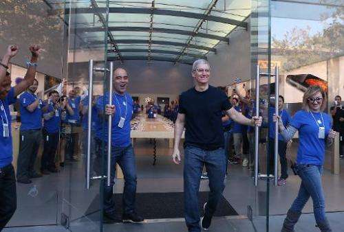 Apple CEO Tim Cook (R) opens the door to an Apple Store to begin sales of the new iPhone 6 on September 19, 2014 in Palo Alto, C