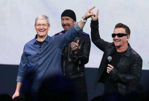 Apple CEO Tim Cook (L) greets the crowd with U2 singer Bono (R) during an Apple special event at the Flint Center for the Perfor