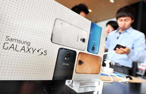 A customer looks at Samsung's Galaxy S5 smartphone at a mobile phone shop in Seoul on March 27, 2014
