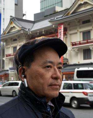 An engineer of Japanese machinery maker NS West wears the 'Earclip-type Wearable PC', equipped with vital sensors such as pulse 
