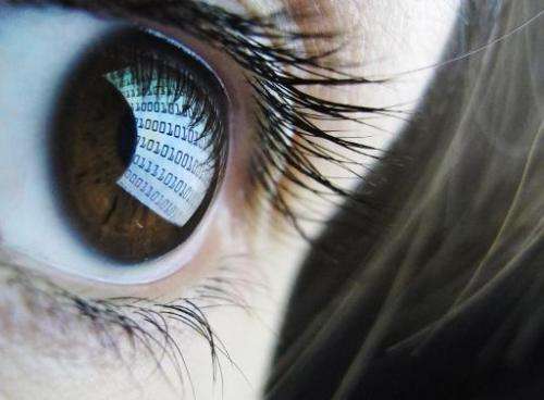 A picture shows binary code reflected from a computer screen in a woman's eye