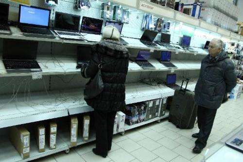 Customers look at laptops in a shop in the Russian town of Klintsy, near the border with Belarus, on December 20, 2014