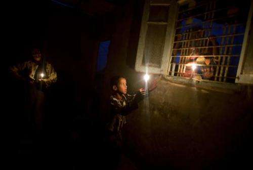 In this file photo, a Palestinian woman and her children light candles during a power outage in Gaza City, on November 10, 2013