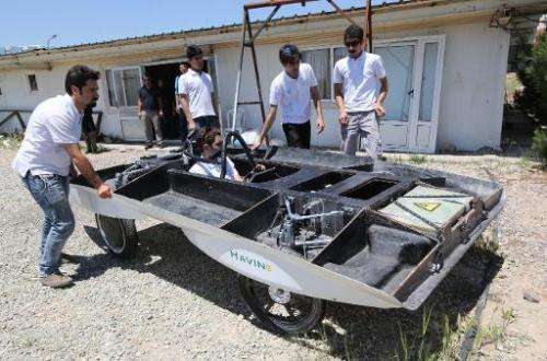 Iranian students from Qazvin Azad Islamic University assemble the solar-powered Havin-2 vehicle for a test drive in Qazvin on Ju