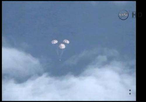 This image taken from a NASA video, shows the Orion spacecraft and its the parachutes as it descends to the Pacific Ocean on Dec