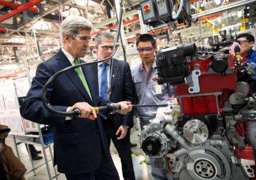 US Secretary of State John Kerry (L) torques an engine bolt during a tour of the Cummins-Foton plant in Beijing on February 15, 