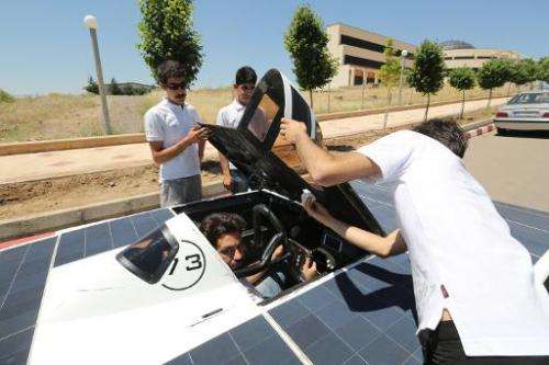 Iranian students from Qazvin Azad Islamic University assemble the solar-powered Havin-2 vehicle for a test drive in Qazvin on Ju
