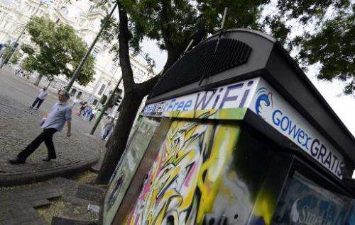 People walk past a kiosk with an advertisement for wifi provider Gowex in Madrid, on July 3, 2014