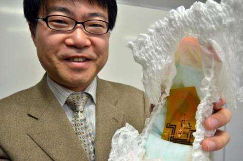 University of Tokyo professor Takao Someya pictured with the world's first disposable wireless organic sensor embedded in a diap