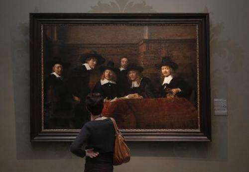 A visitor looks at a work by Dutch artist Rembrandt Harmensz van Rijn entitled &quot;The Syndics of the Amsterdam drapers' Guild