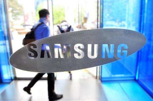A visitor walks past a logo of Samsung Electronics at the company's headquarters in Seoul on April 29, 2014