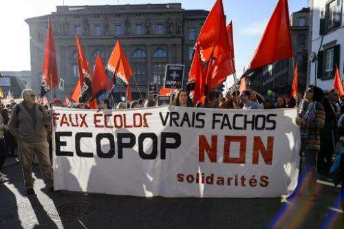 Demonstrators hold a banner reading in French &quot;Fake ecologists, real fascists, No to ECOPOP&quot; during a demonstration in