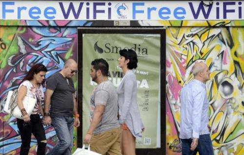 People walk past an advertisement for wifi provider Gowex in Madrid, on July 3, 2014