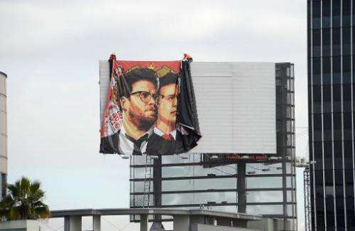 Workers remove a poster for &quot;The Interview&quot; from a billboard in Hollywood on December 18, 2014